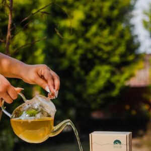 a person pouring tea into a teapot