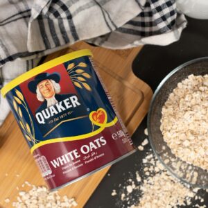 A bowl of oats next to a can of milk