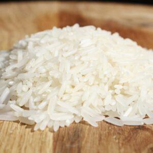 A pile of rice sitting on top of a wooden cutting board